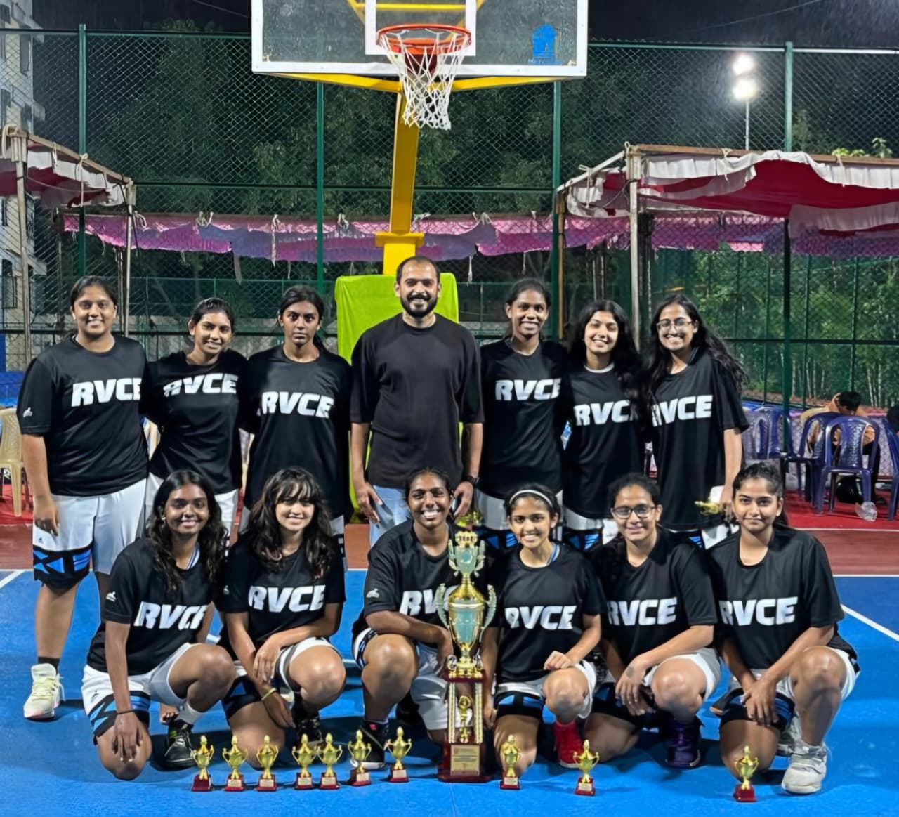 RVCE women's basketball team with trophies on court
