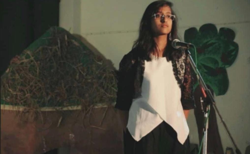 Hrishika speaking on stage at school